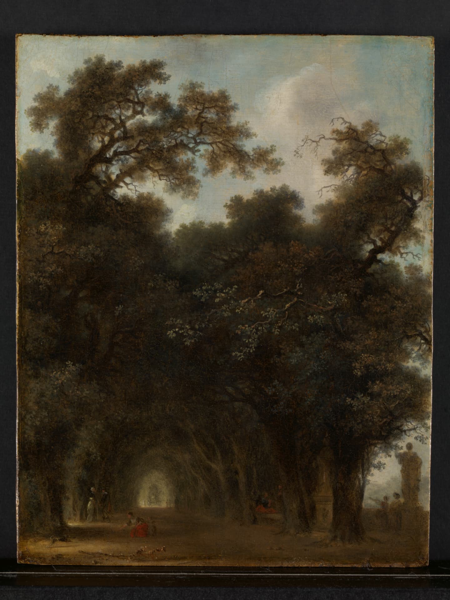 Jean Honoré Fragonard, A Shaded Avenue, ca. 1775. Oil on wood: very large arching trees form a shaded tunnel over a path, with small figures walking and sitting beneath them.